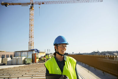 Portrait of smiling man at construction site against sky