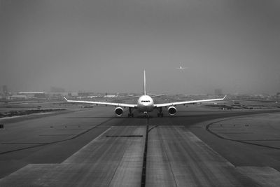 Airplane on runway against sky