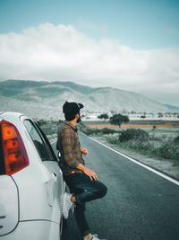 Rear view of man standing on road against sky