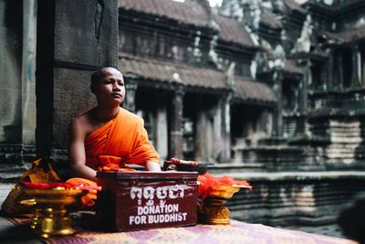 Woman looking at temple against building