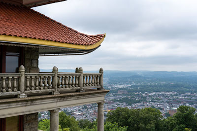 Roof of building by city against sky