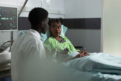 Young man using mobile phone while sitting on bed