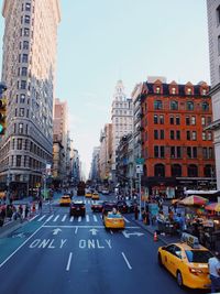 Cars on road in city against sky