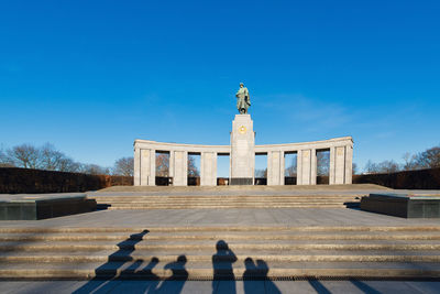 Statue of historic building against blue sky