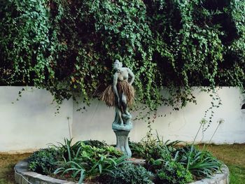 Statue against plants