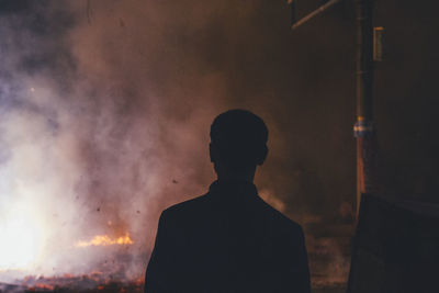 Rear view of silhouette man standing at night