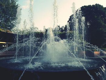 Water splashing in fountain against sky