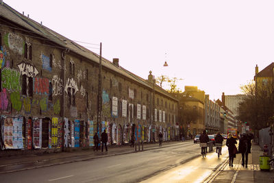 People walking on street against buildings in city