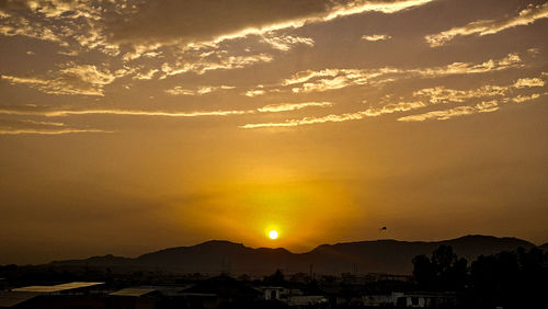 Scenic view of silhouette mountains against romantic sky at sunset