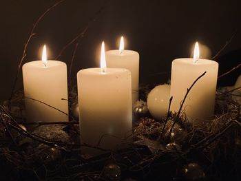 Close-up of illuminated candles in the dark