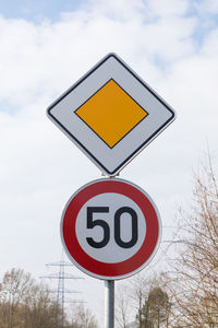 Low angle view of road sign against sky