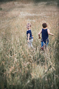 Siblings walking on field