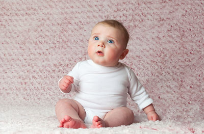 Cute baby boy sitting on bed