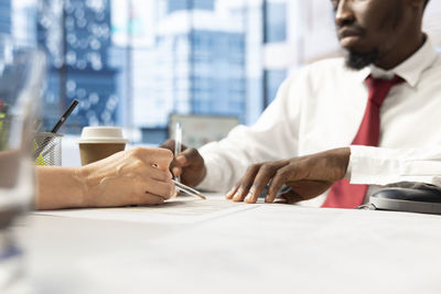 Midsection of business people working at office