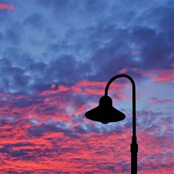 Low angle view of silhouette street light against dramatic sky