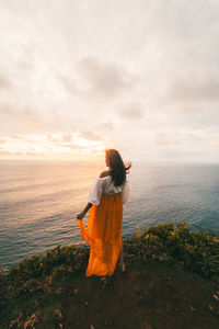 Rear view of woman looking at sea against sky