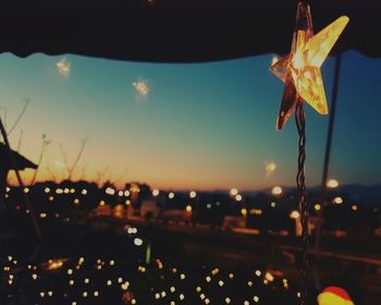 Close-up of illuminated lights against sky at night