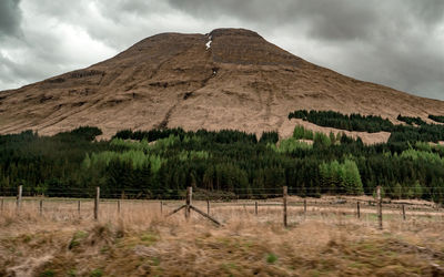 Scenic view of mountain range against cloudy sky