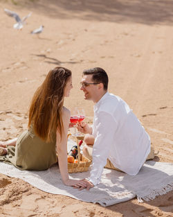 Couple of a man and a woman on a date are walking and drinking wine. a couple in love is relaxing 