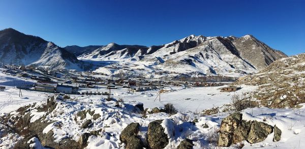 Scenic view of snowcapped mountains against clear blue sky