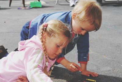 Siblings coloring on road in city