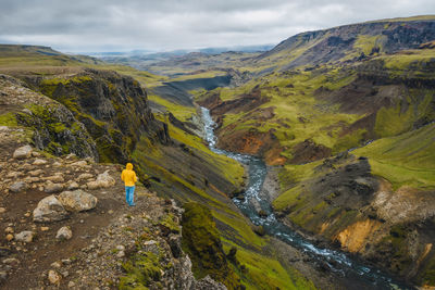 Rear view of man on mountain against sky