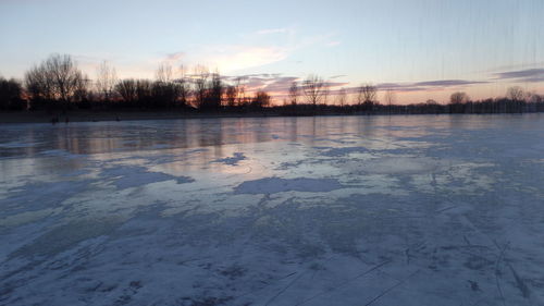 Scenic view of frozen lake against sky during winter