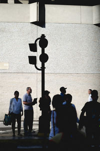 Rear view of people walking on wall