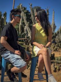 Young couple sitting on chairs and talking to each other.