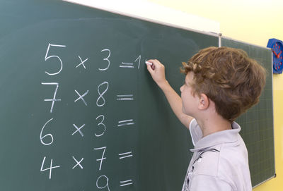 Student solving mathematics on blackboard