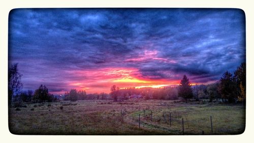 Scenic view of field against dramatic sky