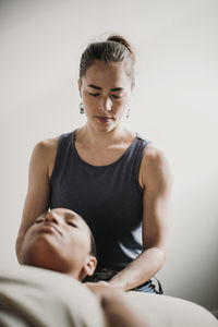 African american woman receives massage treatment from her therapist