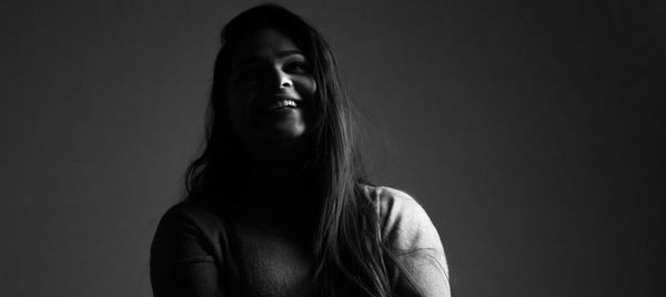 Smiling young woman sitting at home