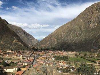 Aerial view of townscape and mountains against sky