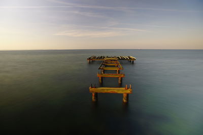 Boat in sea against sky during sunset