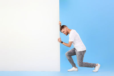 Side view of man standing against clear blue sky