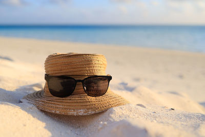 Close-up of sunglasses on beach