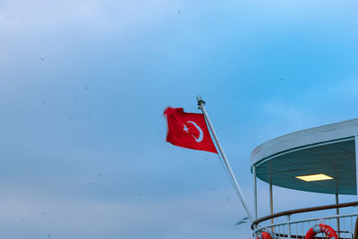 Low angle view of flag flags against blue sky