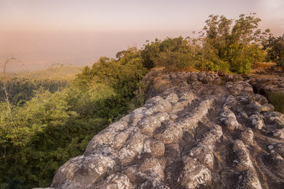 Rock on landscape against sky during sunset