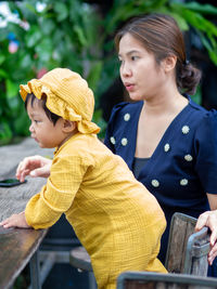 Portrait of smiling young woman looking away while sitting outdoors