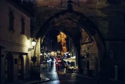 Illuminated street amidst buildings in city at night