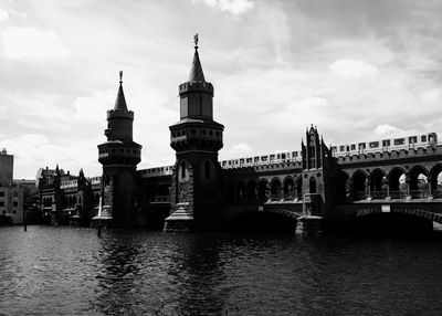 Arch bridge over river against buildings in city