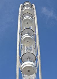 Low angle view of white ferris wheel against sky on sunny day