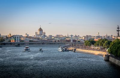 Boats in river with buildings in background