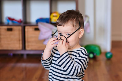 Cute baby boy is playing with toy glasses