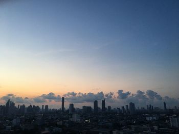 Buildings in city against sky during sunset