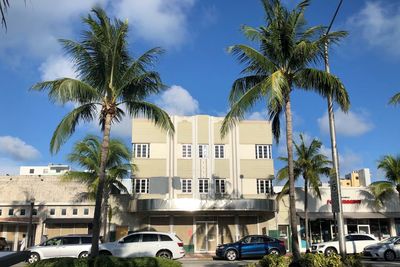 Palm trees by buildings against sky