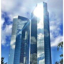 Low angle view of modern building against cloudy sky