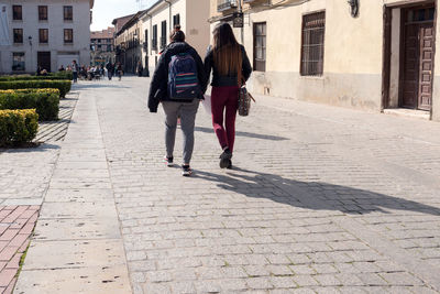 Rear view of man and woman walking in city
