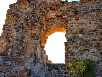 Low angle view of old stone wall against sky